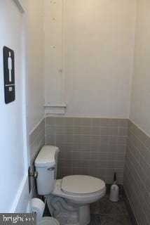 577 Winchester St, Paw Paw, WV 25434 - half bathroom with toilet, wainscoting, tile walls, and tile patterned flooring