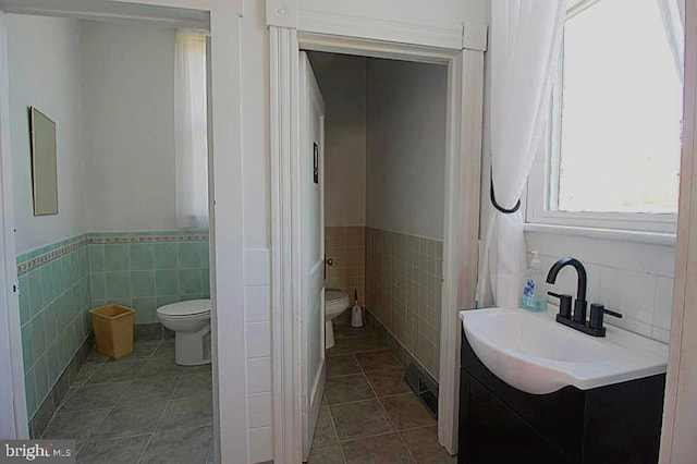 577 Winchester St, Paw Paw, WV 25434 - bathroom with toilet, tile walls, a wainscoted wall, tile patterned floors, and vanity
