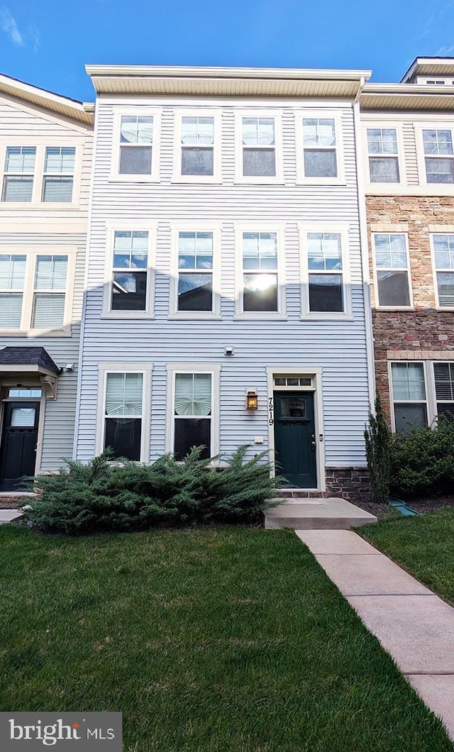 view of property with stone siding and a front yard