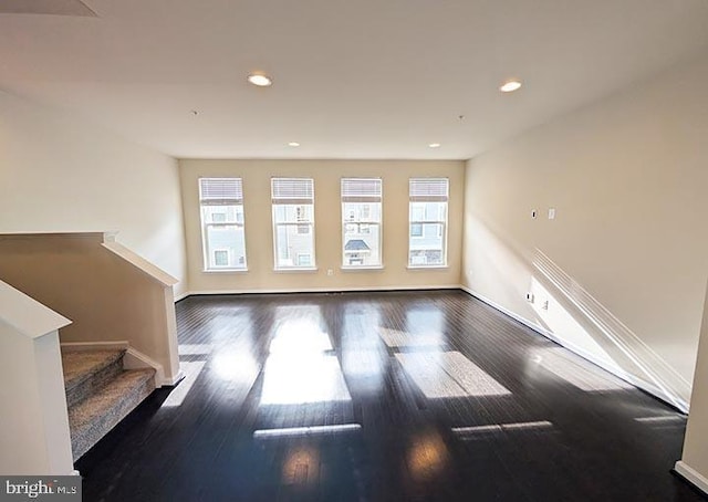 interior space featuring a healthy amount of sunlight, baseboards, and wood finished floors