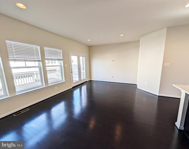 empty room featuring recessed lighting, visible vents, plenty of natural light, and dark wood finished floors