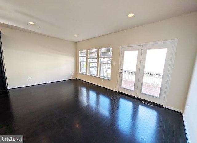 empty room featuring visible vents, recessed lighting, baseboards, and dark wood-type flooring