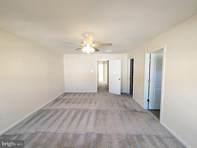 spare room featuring baseboards, ceiling fan, and carpet