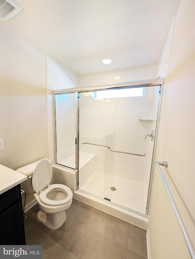 bathroom featuring visible vents, tile patterned flooring, vanity, toilet, and a stall shower