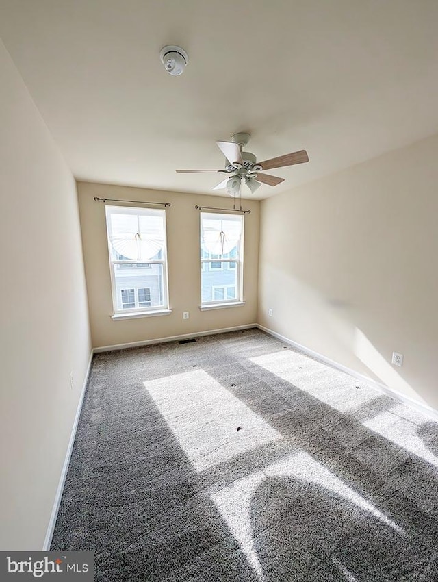 spare room featuring baseboards, a ceiling fan, carpet, and visible vents