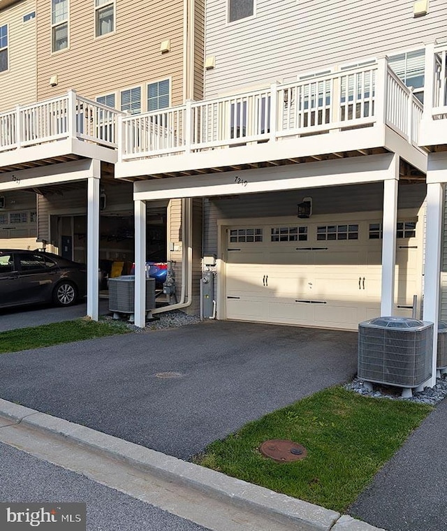 exterior space with a garage, central AC unit, and driveway