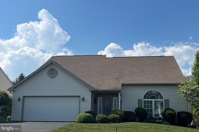 view of front of property with a garage, a shingled roof, a front lawn, and aphalt driveway