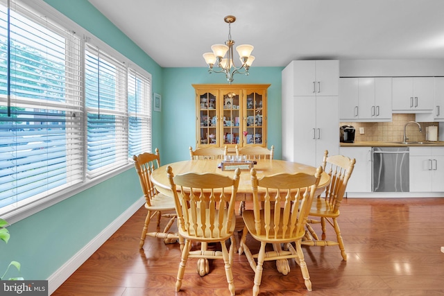 dining space featuring baseboards, a chandelier, and light wood-style flooring