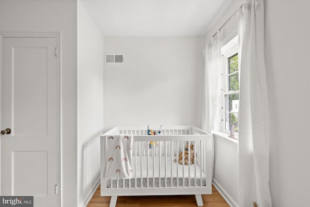 1705 N Cliff St, Alexandria, VA 22301 - bedroom featuring wood finished floors, a nursery area, and baseboards