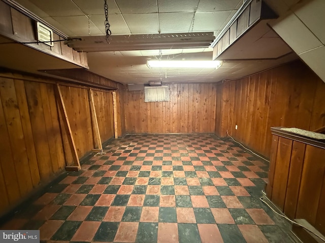 finished basement with wood walls and tile patterned floors