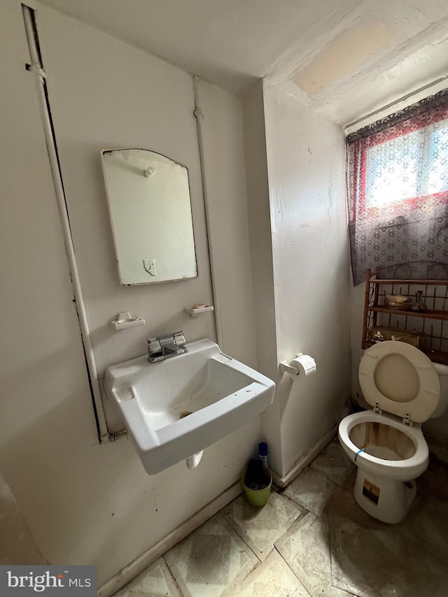 half bathroom featuring a sink and toilet
