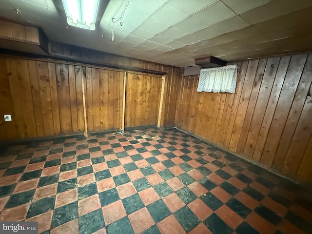 finished below grade area featuring wood walls and tile patterned floors