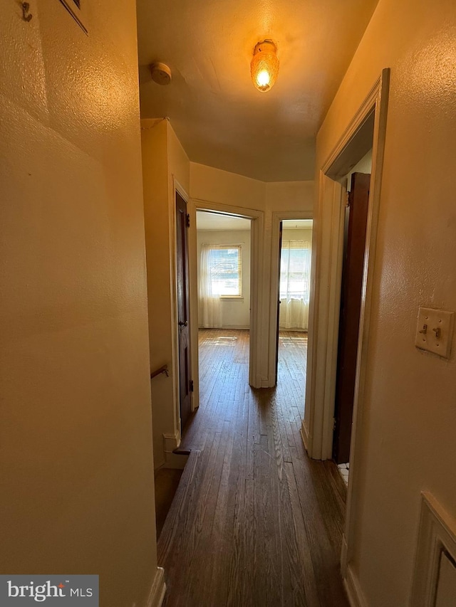 hallway featuring baseboards and hardwood / wood-style floors