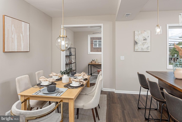 dining area featuring baseboards, visible vents, and dark wood-type flooring