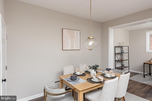 dining area featuring dark wood-type flooring and baseboards