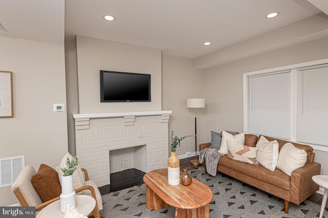 living area with a brick fireplace, recessed lighting, baseboards, and visible vents