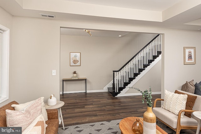 living area featuring visible vents, baseboards, stairs, and wood finished floors
