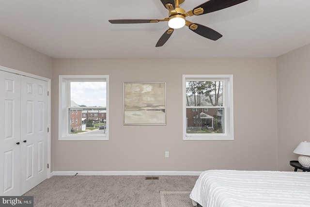 bedroom featuring carpet, a ceiling fan, baseboards, visible vents, and a closet