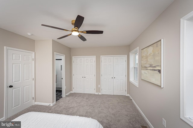 bedroom with carpet floors, baseboards, multiple closets, and ceiling fan