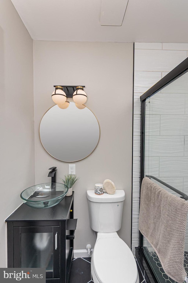 bathroom featuring vanity, baseboards, walk in shower, and toilet