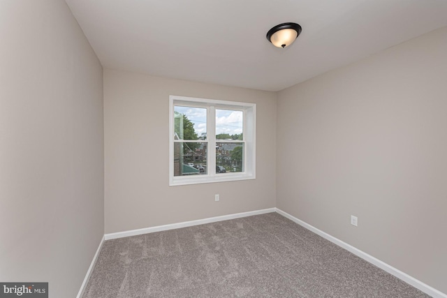 unfurnished room with baseboards and carpet
