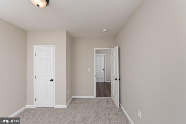 unfurnished bedroom with carpet floors and baseboards