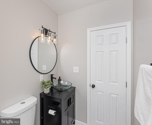 bathroom with toilet, baseboards, and vanity