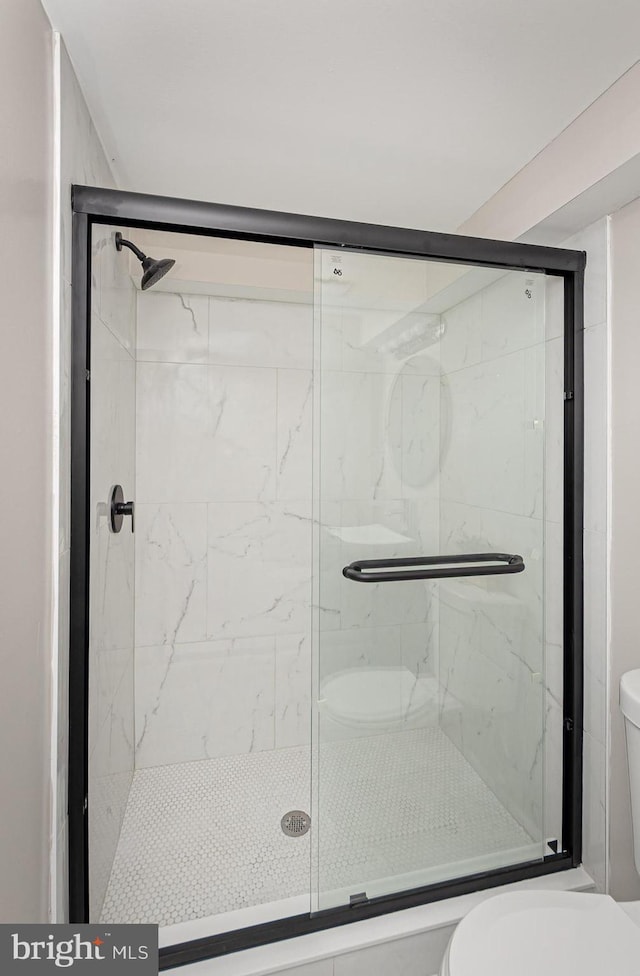full bath featuring a stall shower and toilet