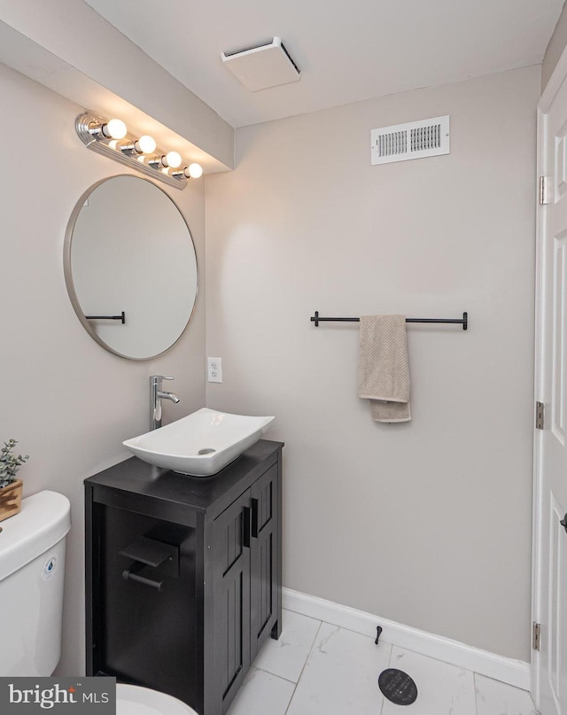 bathroom featuring visible vents, vanity, baseboards, toilet, and marble finish floor