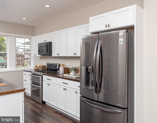 kitchen featuring dark wood-style flooring, stainless steel appliances, dark countertops, and white cabinets