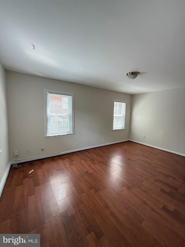 empty room featuring baseboards and wood finished floors