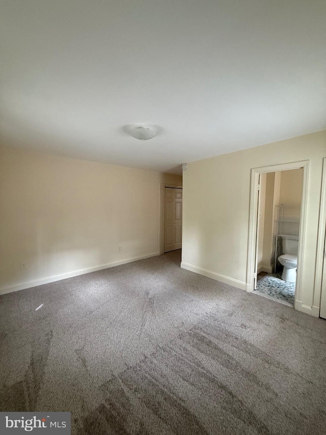 carpeted spare room featuring baseboards
