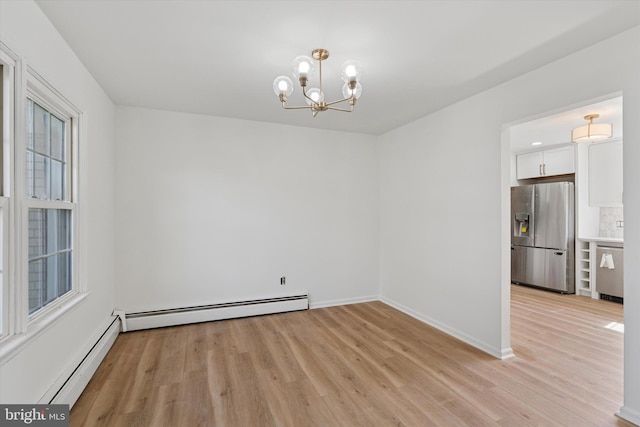 interior space featuring baseboard heating, baseboards, a baseboard radiator, light wood finished floors, and an inviting chandelier