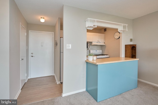 kitchen with visible vents, white appliances, baseboards, light countertops, and under cabinet range hood