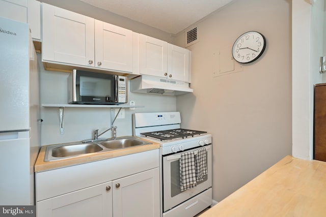 kitchen featuring visible vents, white appliances, under cabinet range hood, white cabinets, and a sink