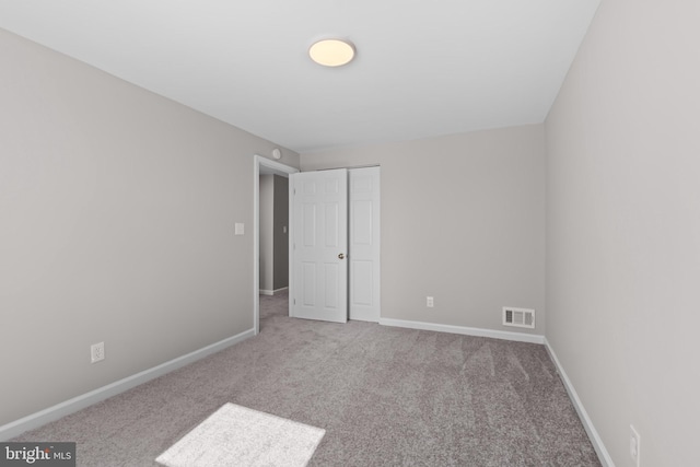 unfurnished bedroom featuring carpet, baseboards, a closet, and visible vents