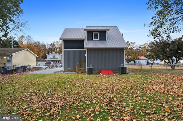 41 S Mechanic St, Camden Wyoming, DE 19934 - rear view of property featuring a fenced backyard, a lawn, cooling unit, and metal roof
