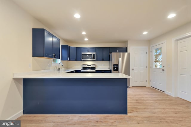 41 S Mechanic St, Camden Wyoming, DE 19934 - kitchen with a peninsula, light wood-style floors, light countertops, stainless steel appliances, and blue cabinetry