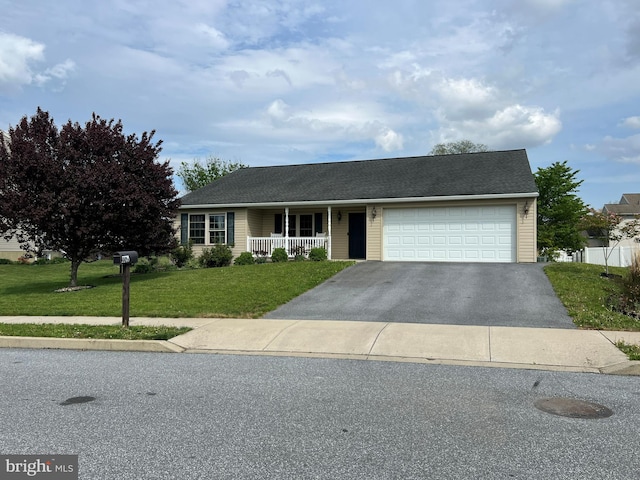 ranch-style home featuring an attached garage, a front yard, covered porch, and driveway