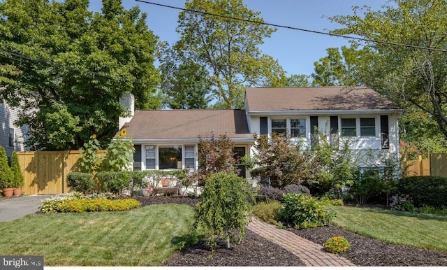 tri-level home with fence and a front yard