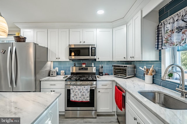 1016 Leiper St, Crum Lynne, PA 19022 - kitchen with crown molding, a toaster, white cabinetry, a sink, and appliances with stainless steel finishes