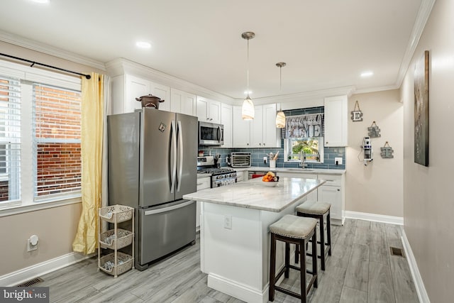1016 Leiper St, Crum Lynne, PA 19022 - kitchen with stainless steel appliances, baseboards, white cabinetry, and light wood finished floors