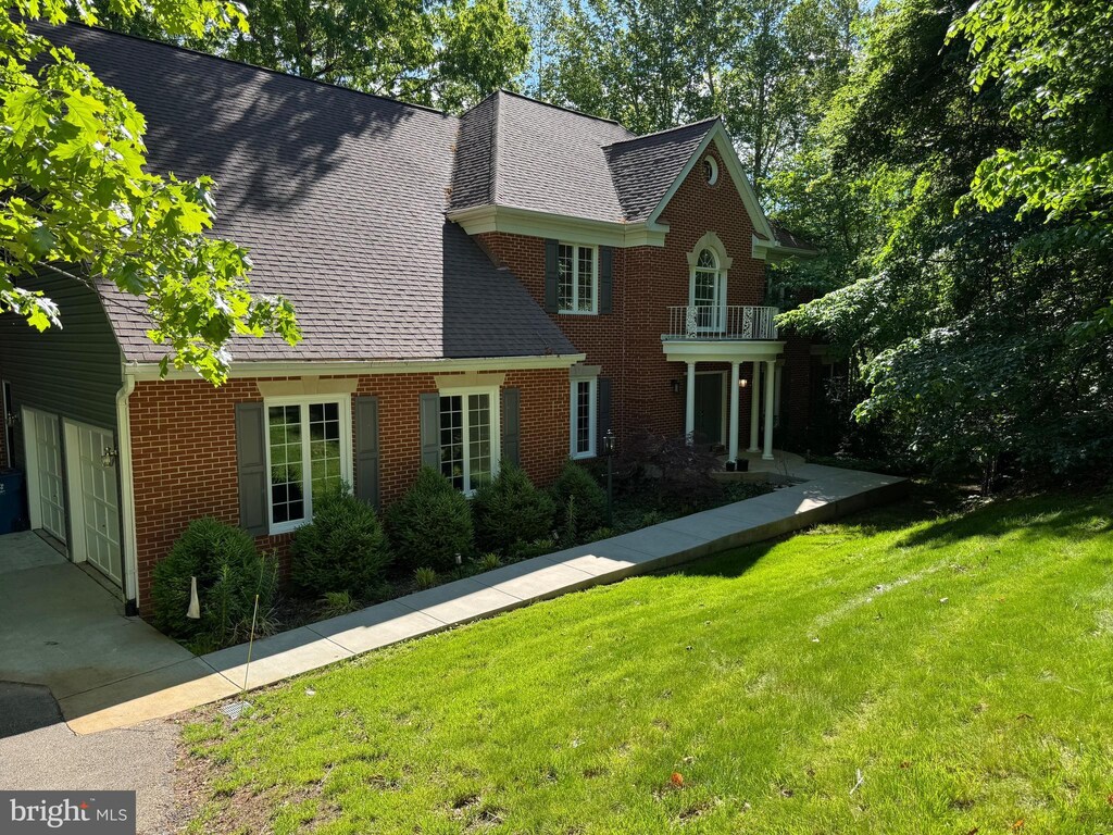 6689 Highpoint Ct, Manassas, VA 20112 - view of front of property with brick siding, a balcony, a front yard, a shingled roof, and an attached garage