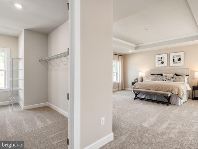 carpeted bedroom featuring baseboards, ornamental molding, a tray ceiling, and recessed lighting