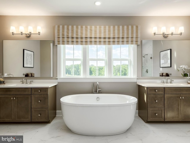 full bathroom with plenty of natural light, a sink, and marble finish floor