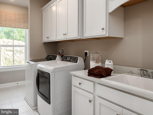 washroom featuring independent washer and dryer, cabinet space, a sink, baseboards, and marble finish floor