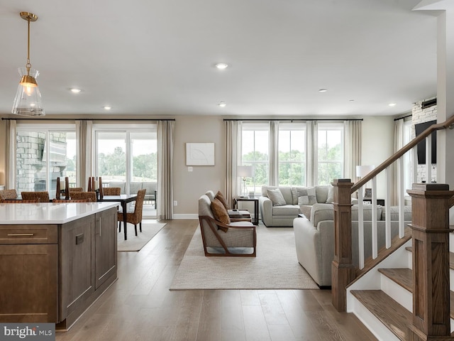 living room featuring stairway, recessed lighting, hardwood / wood-style flooring, and a wealth of natural light