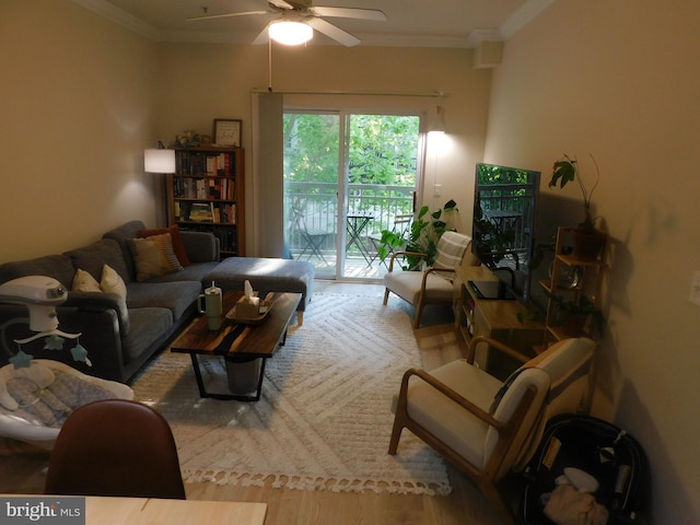 living area with crown molding, a ceiling fan, and wood finished floors