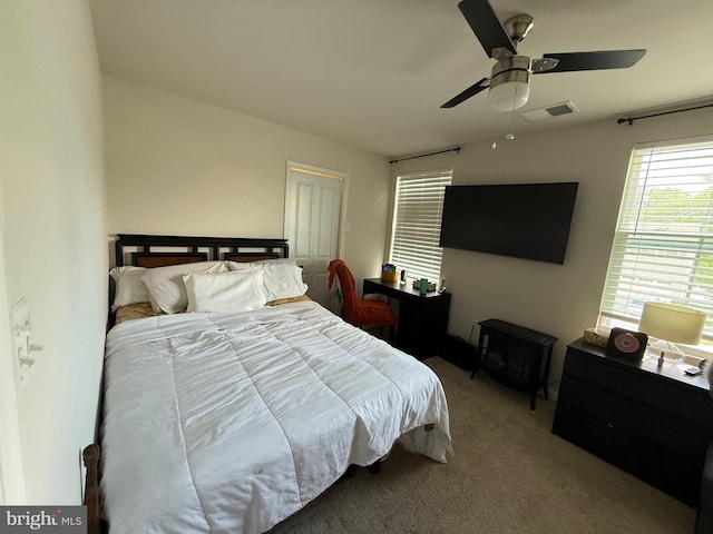 carpeted bedroom featuring ceiling fan and visible vents