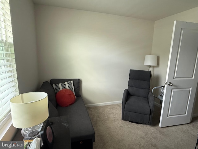 sitting room featuring baseboards, carpet, and a healthy amount of sunlight